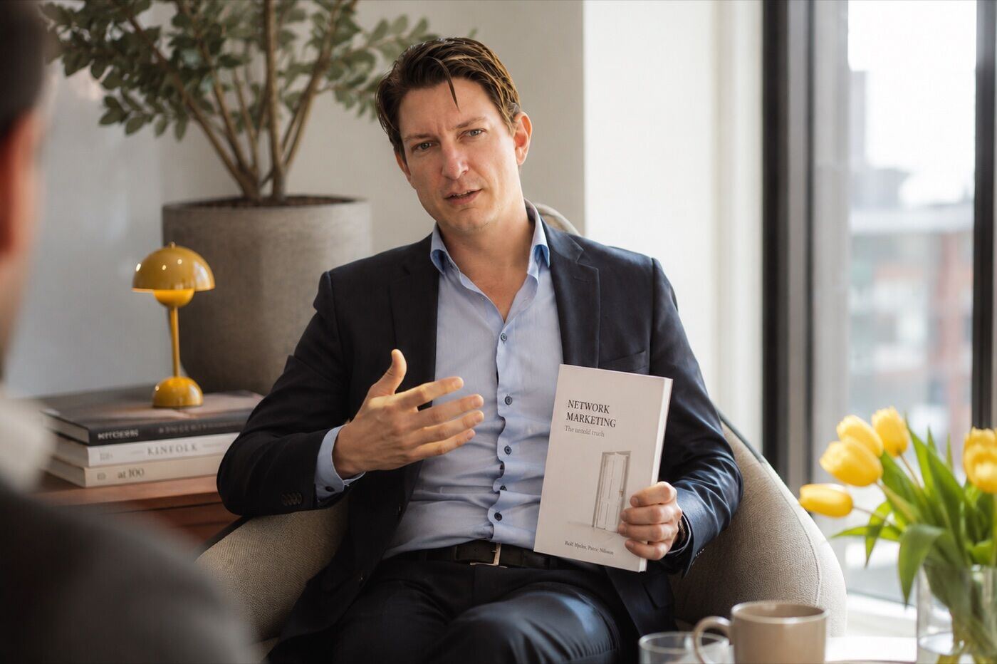 Patric Nilsson in conversation, holding the book